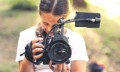 Cute girl walking in the forest and shooting a video using a professional video camera